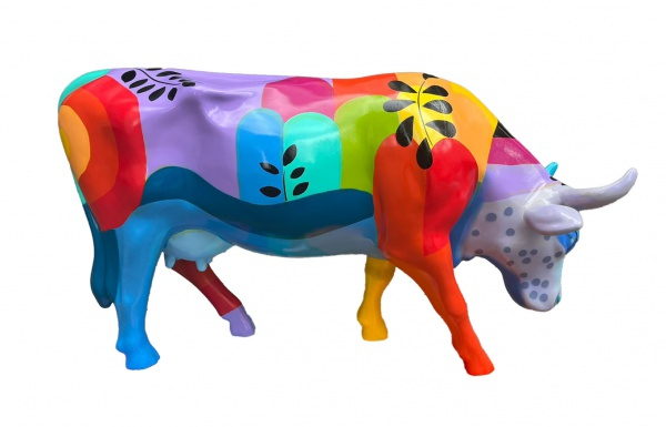 Escultura de vaca pintada en bloques de colores con hojas
