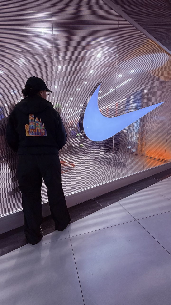 L'artiste devant la vitrine Nike, portant le sweat à la cathédrale