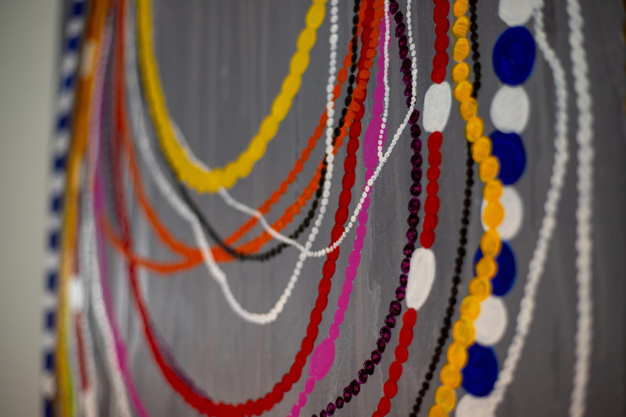 Détail du panneau de fils de perles sur fond gris