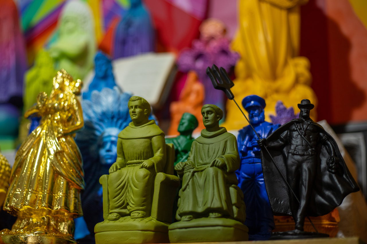 Green friars, a gilded figure and a black figurine among the saints