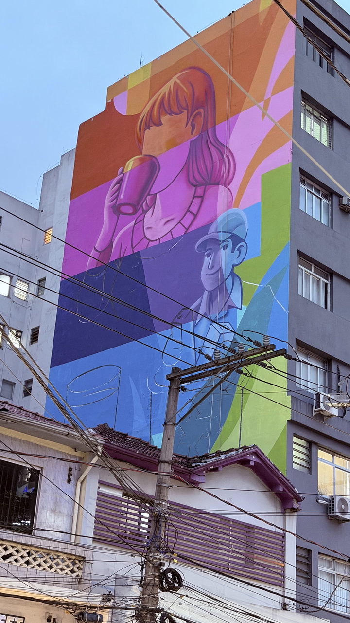 Mural de empena: menina bebendo leite e entregador