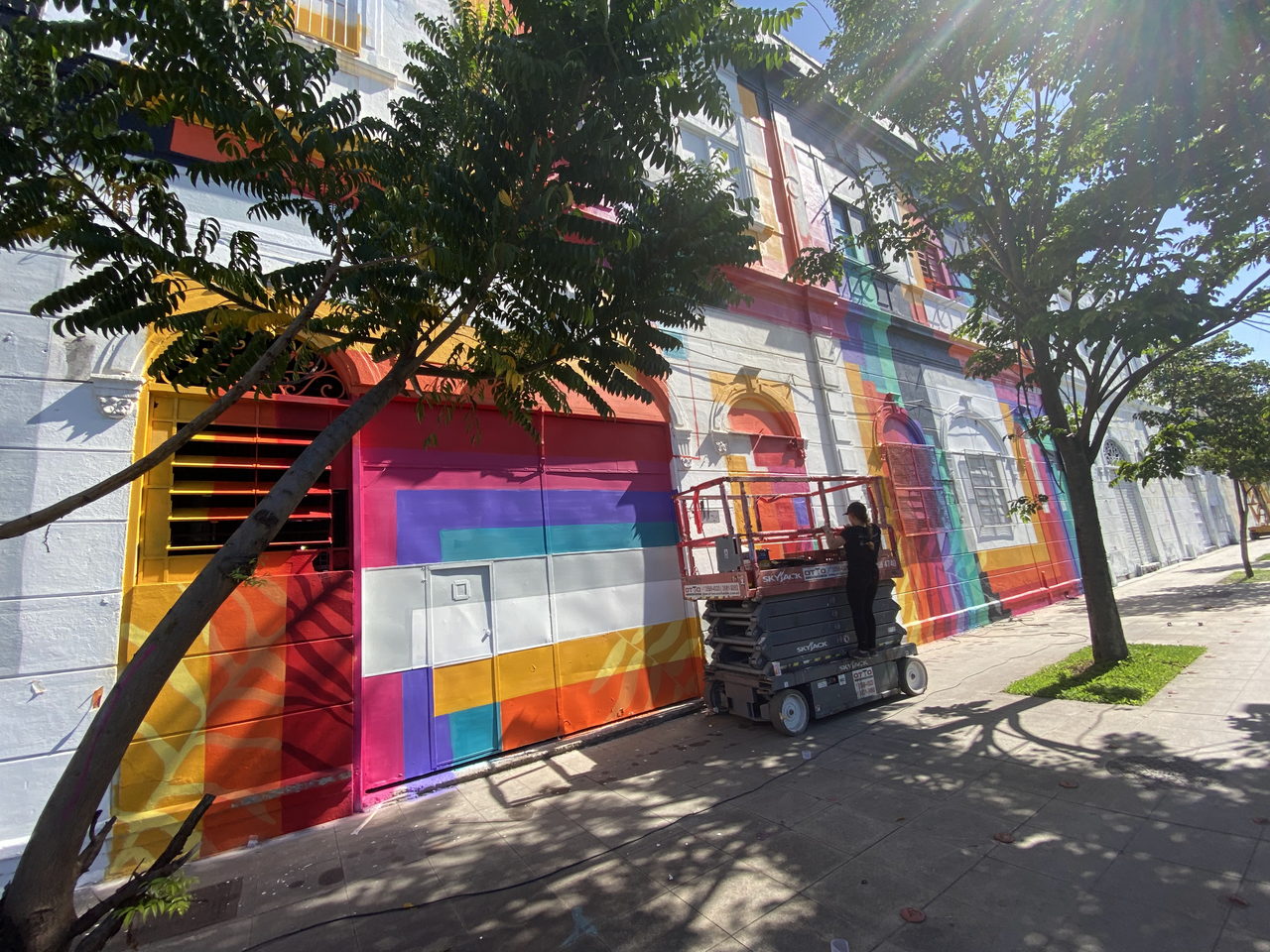 Regenbogenfassade in Arbeit mit Maler auf der Hubbühne