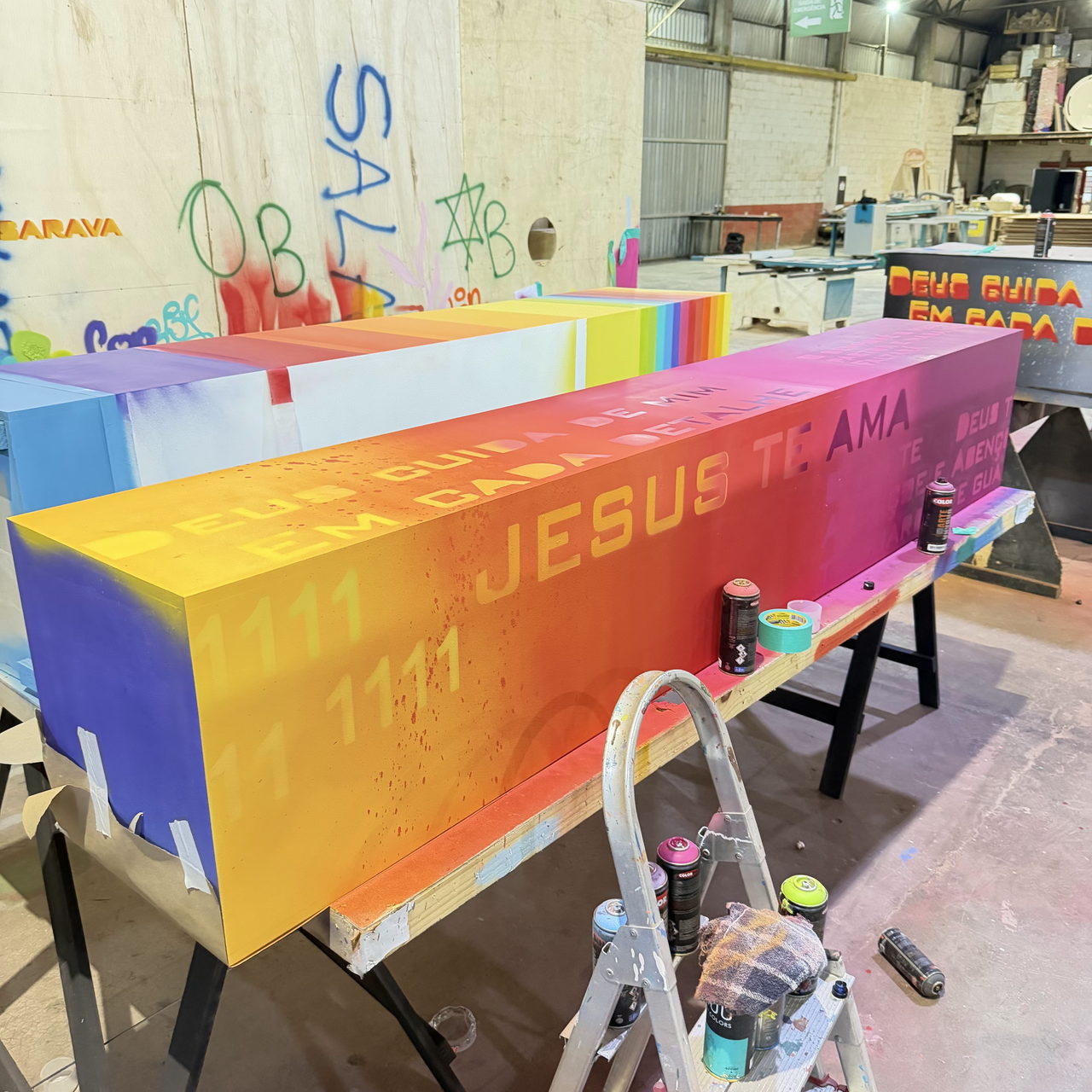 Beam painted in a gradient with the words 'JESUS TE AMA'