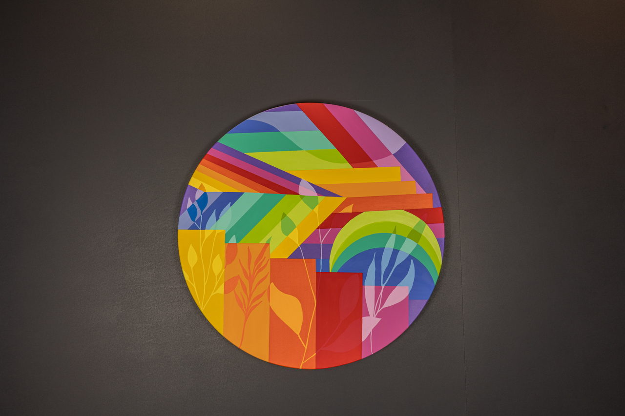 Toile ronde avec des faisceaux arc-en-ciel et du feuillage
