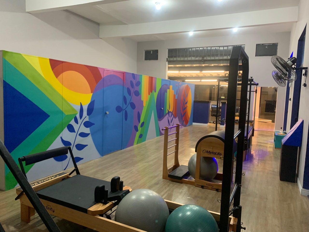 Mural de estúdio de pilates em arco-íris e folhagens azuis