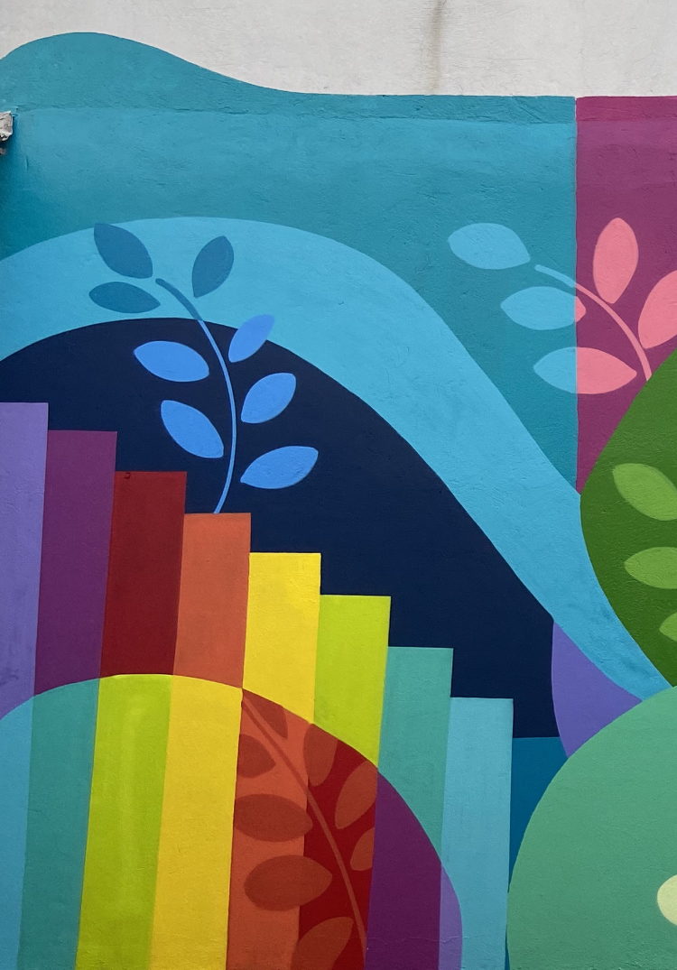 Detalhe de mural com escadaria em arco-íris e folhagens azuis