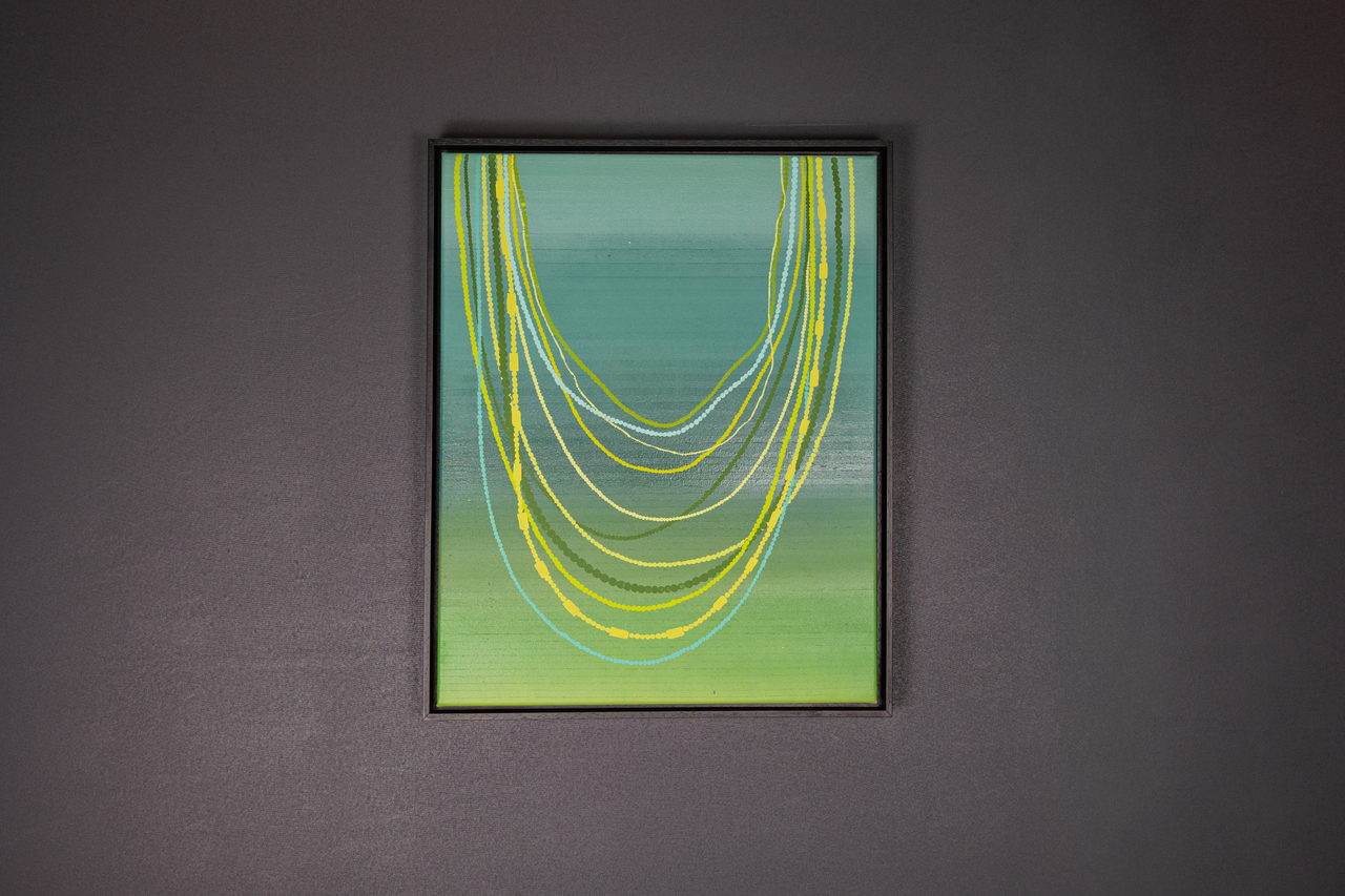 Toile de colliers de perles sur un dégradé vert