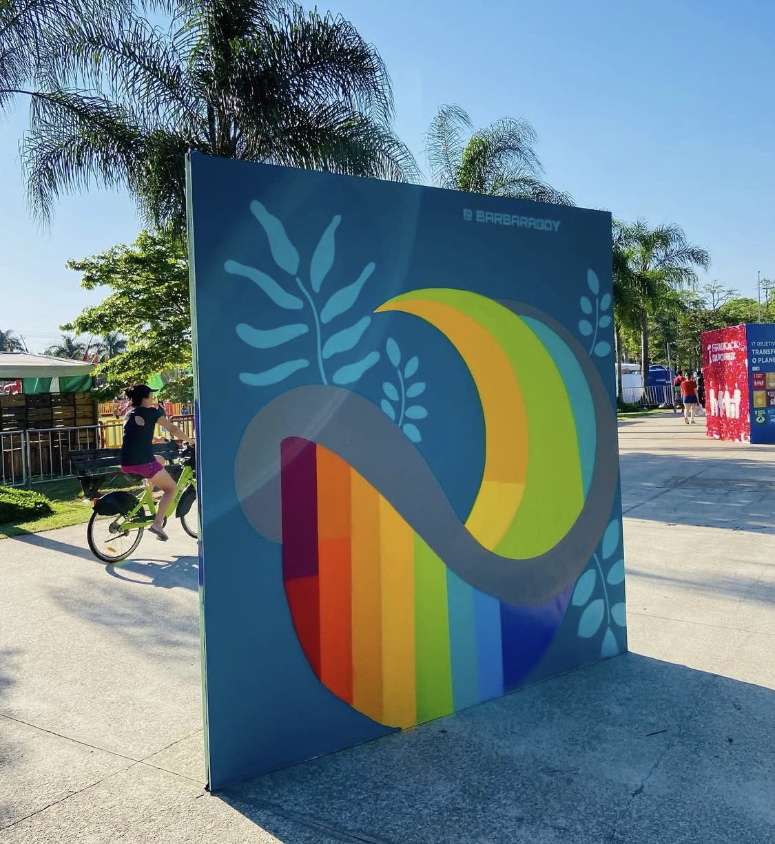 Painel de evento com onda em arco-íris e assinatura @barbaragoy
