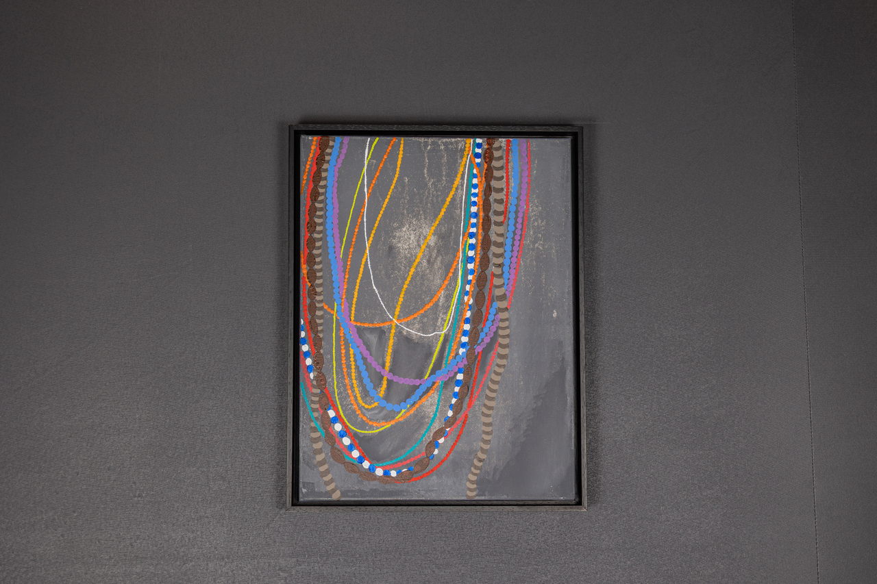 Toile avec de fins colliers multicolores sur fond gris foncé