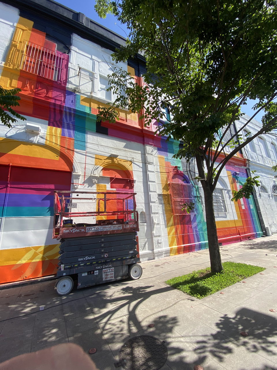 Fassade in Regenbogenstreifen mit Scherenbühne